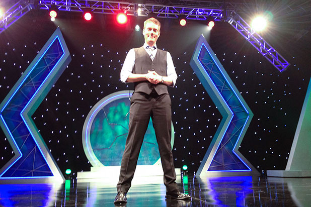 Mentalist for hire Joe Skilton standing on a large stage.
