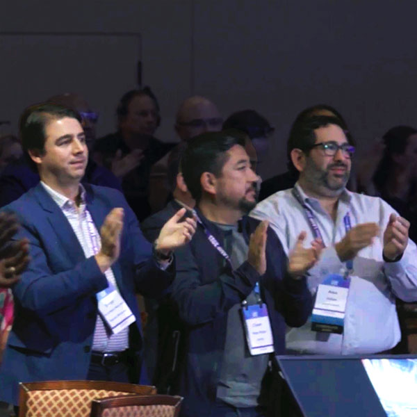 Executives clapping for mentalist Joe Skilton at a conference.