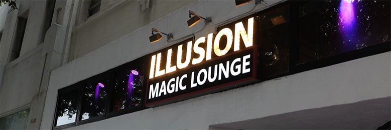 Outdoor sign reading "Illusion Magic Lounge"