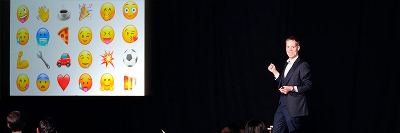 Joe Skilton introduces an interactive video element with emojis during his presentation.
