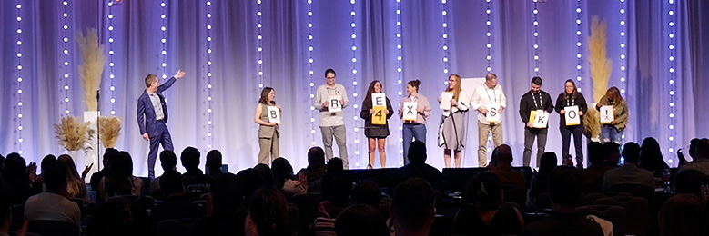 Nine employees join mentalist Joe Skilton on stage during their sales kickoff.
